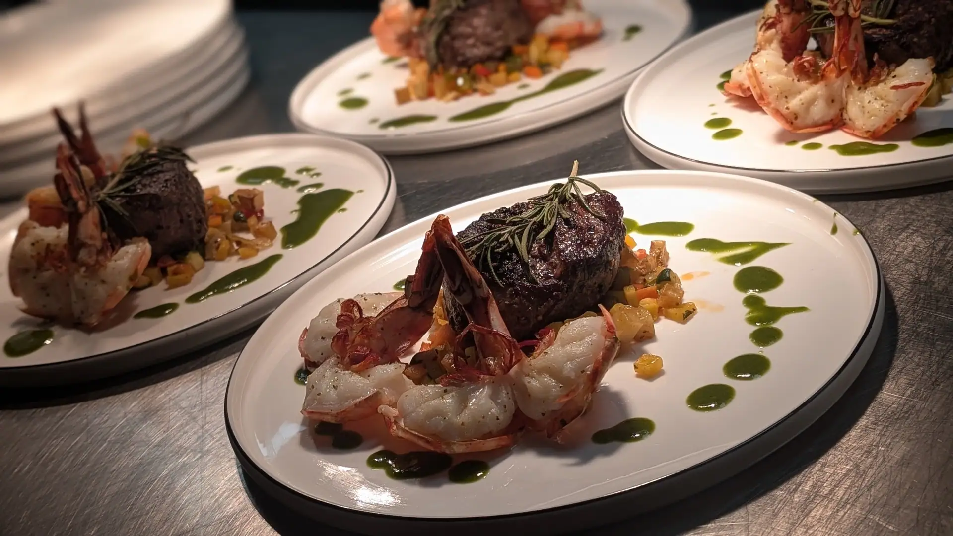 Steaks with prawns, plated at the pass