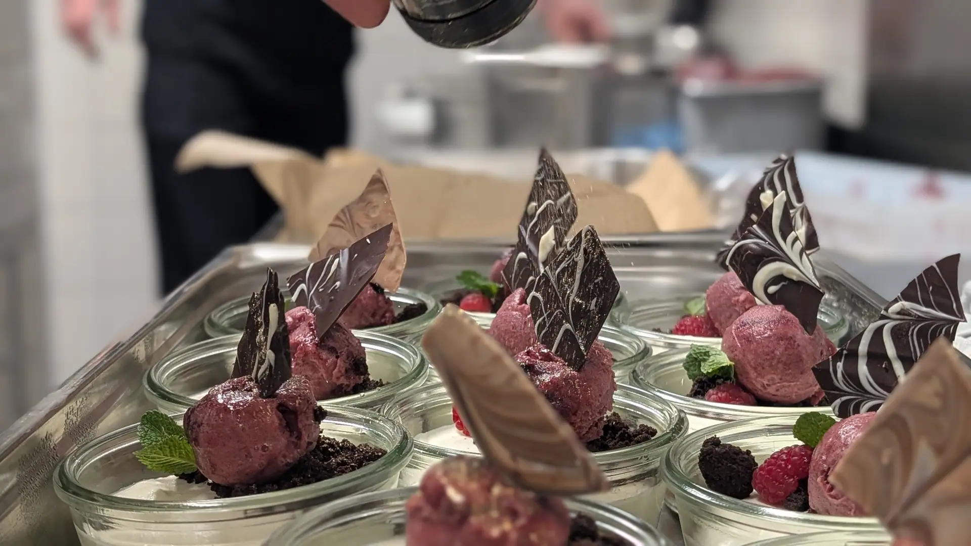 Desserts in glasses with chocolate leaves and berries